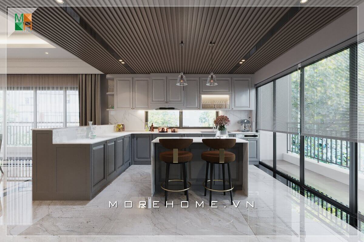 Mẫu thiết kế phòng bếp cho nhà phố, biệt thự, với hệ thống tủ bếp gỗ khắc những chi tiết ô vuông truyền thống, bàn đảo bếp mặt đá nhân tạo hiện đại, ghế bar bọc nỉ cao cấp đến đèn thả trần duyên dáng, tạo nên vẻ đẹp vừa hiện đại sang trọng mà vẫn có nét gì đó cổ điển